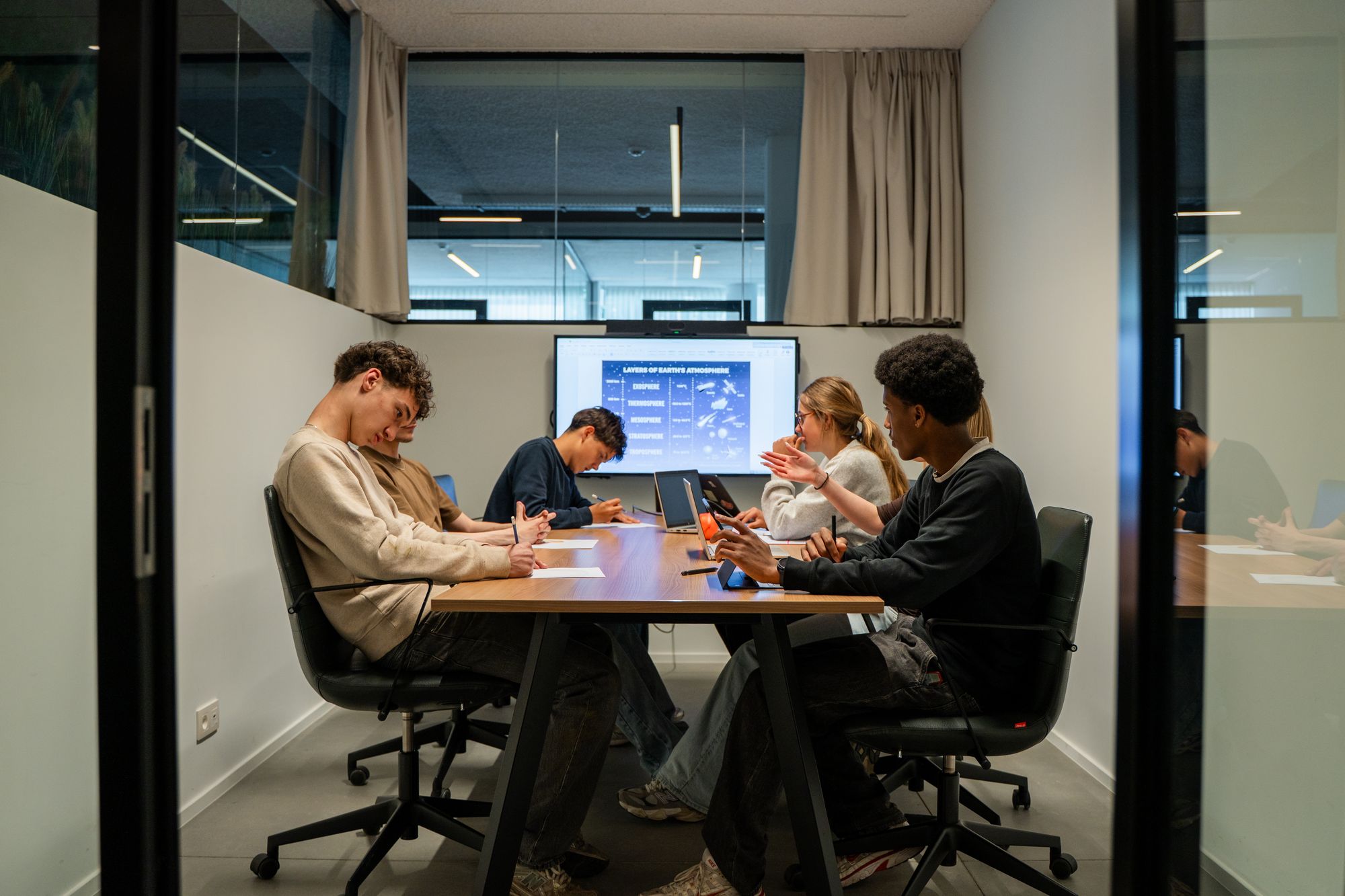 Des jeunes qui travaillent ensemble autour d’une table