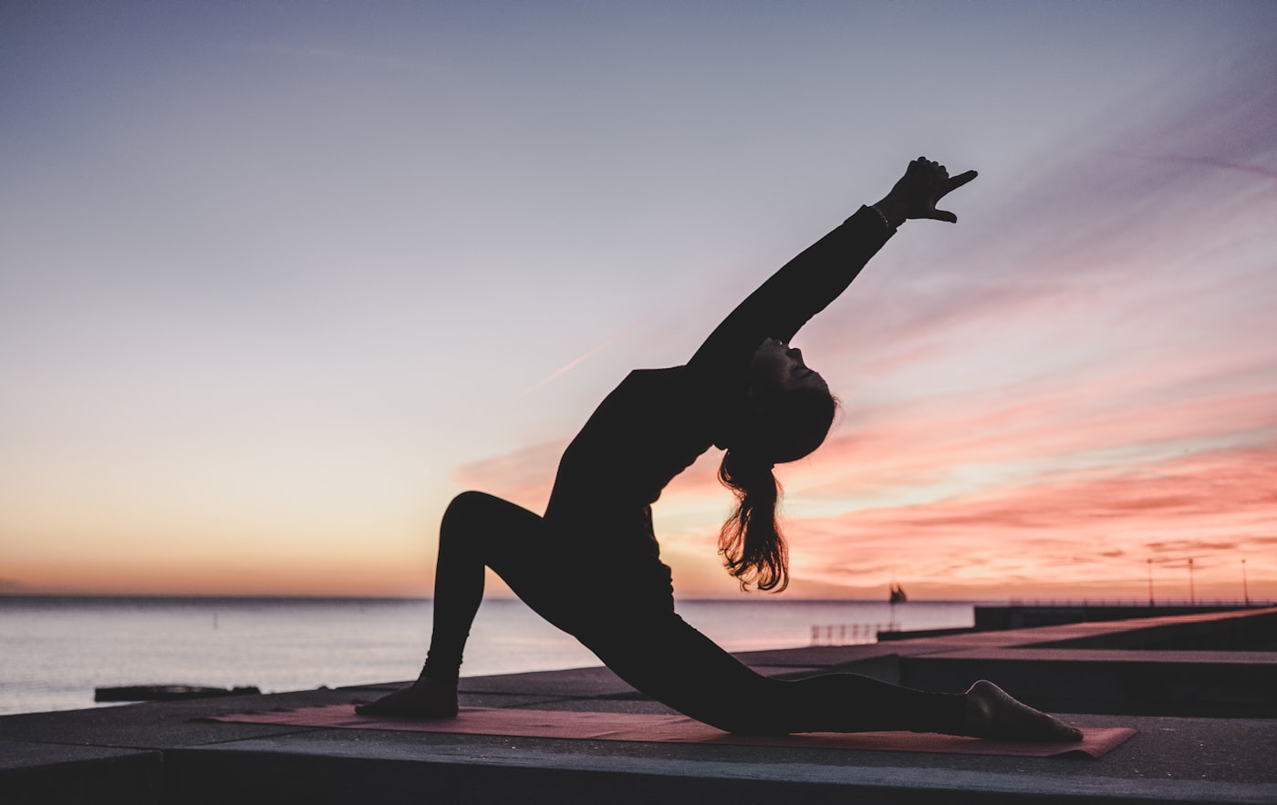 Silhouette stretching at sunset